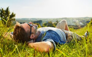 Man lying on grass enjoying peaceful sunny day